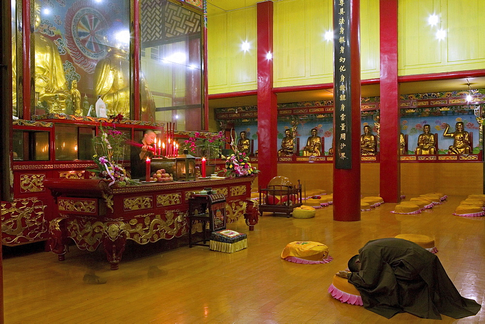 Praying monk at main hall of the Wannian monastery, Emei Shan, Sichuan province, China, Asia