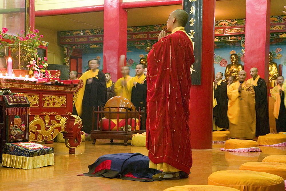 Praying monks at the main hall of the Wannian monastery, Emei Shan, Sichuan province, China, Asia