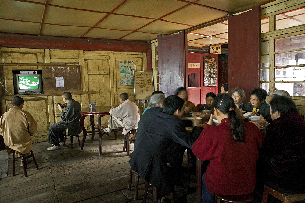 monks having lunch, TV, canteen of the monastery, Xixiang Chi monastery and temple, Elephant Bathing Pool, China, Asia, World Heritage Site, UNESCO