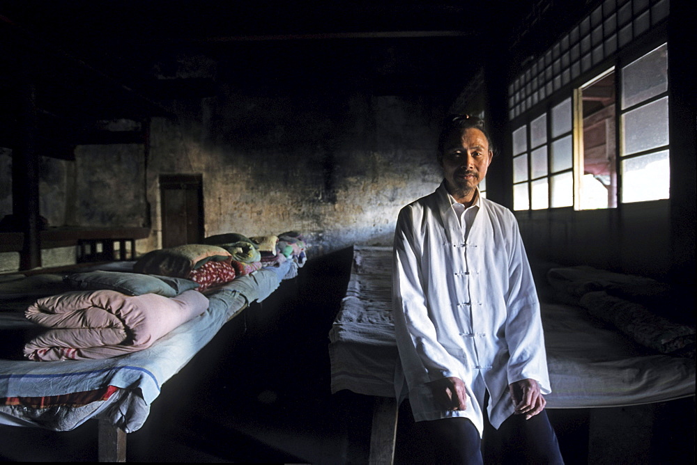 A monk standing at pilgrim's dormitory at Qunxian monastery, Hua Shan, Shaanxi province, China, Asia