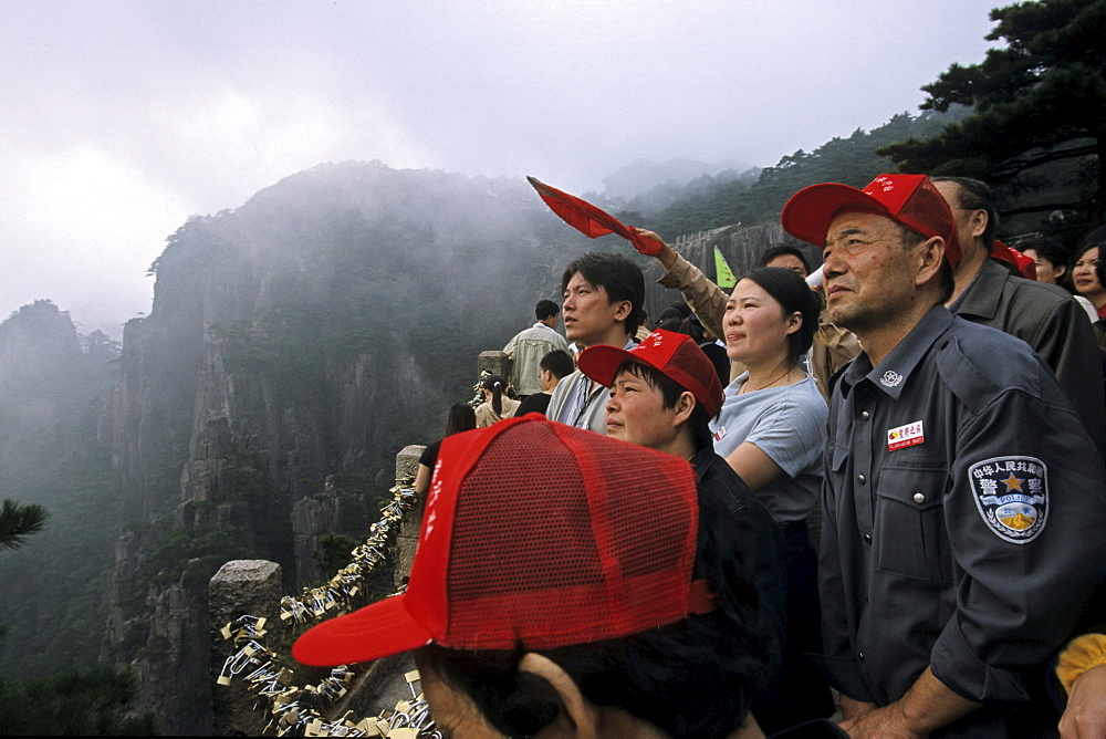 A group of tourists looking at view from peak, Huang Shan, Anhui province, China, Asia