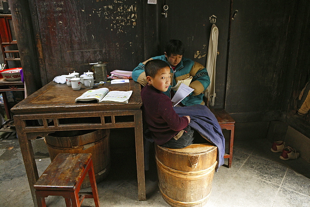 Two boys doing homework in a residential house at the village Hongcun, Huangshan, China, Asia