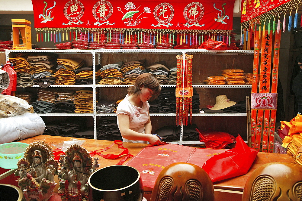 A woman working at a tailor shop for monk's robes, Jiuhuashan, Anhui province, China, Asia