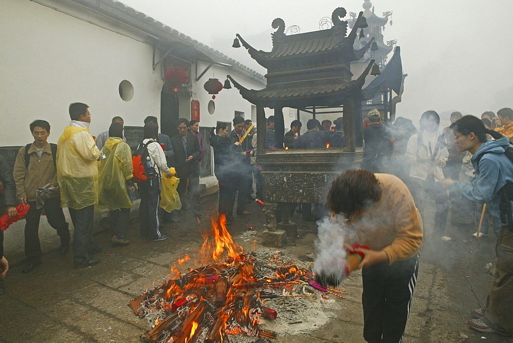 Pilgrims burning incense sticks in front of Longevity monastery, Jiuhua Shan, Anhui province, China, Asia