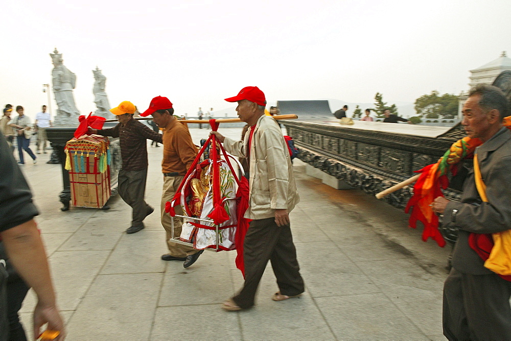 Pilgrims carrying Buddha statue and home altars for a blessing from Guanyin, Goddess of Mercy, Buddhist Island of Putuo Shan near Shanghai, Zhejiang Province, East China Sea, China