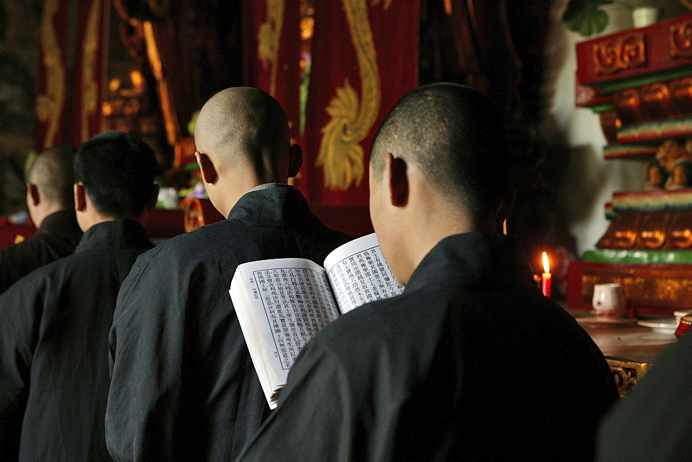 Monks at a prayer service in the Great Buddha Hall, Shaolin Monastery, known for Shaolin boxing, Song Shan, Henan province, China