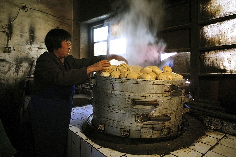 Woman making steamed buns inside the kitchen of Fawang Monastery, Shaolin monastery, known for Shaolin boxing, Taoist Buddhist mountain, Song Shan, Henan province, China