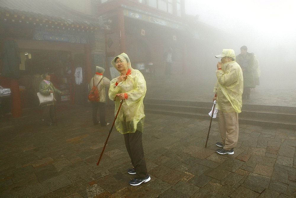 Pilgrims, tourists in rain capes at the entrance to Bixia Si temple, Mount Tai, Tai Shan, Shandong province, World Heritage, UNESCO, China