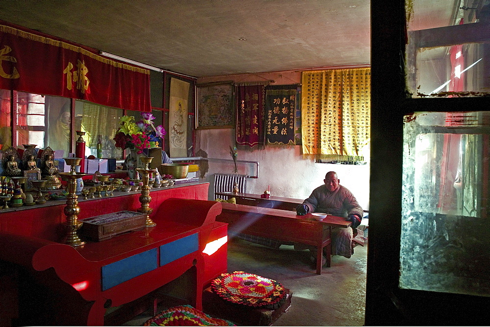 Monk waiting for lunch in the prayer room and dining room, Santa Temple, Mount Wutai, Wutai Shan, Five Terrace Mountain, Buddhist Centre, town of Taihuai, Shanxi province, China