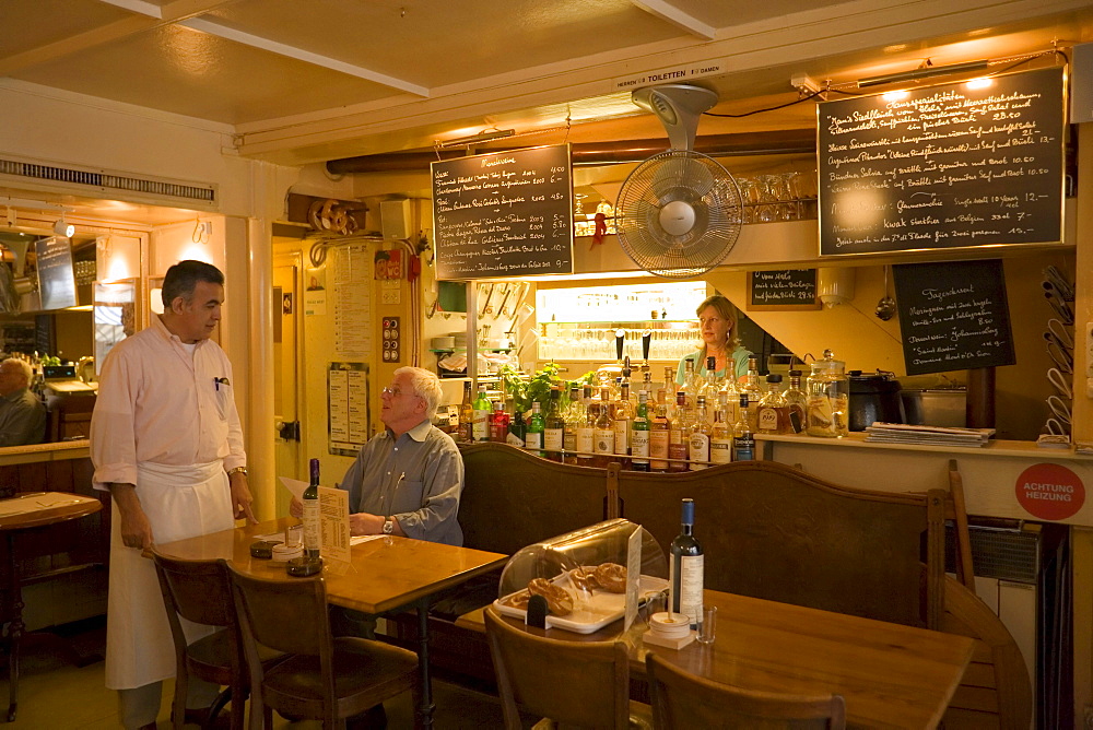 Waiter attending on a guest in the restaurant Weisse Rose (the smallest restaurant of Zurich), Zurich, Canton Zurich, Switzerland