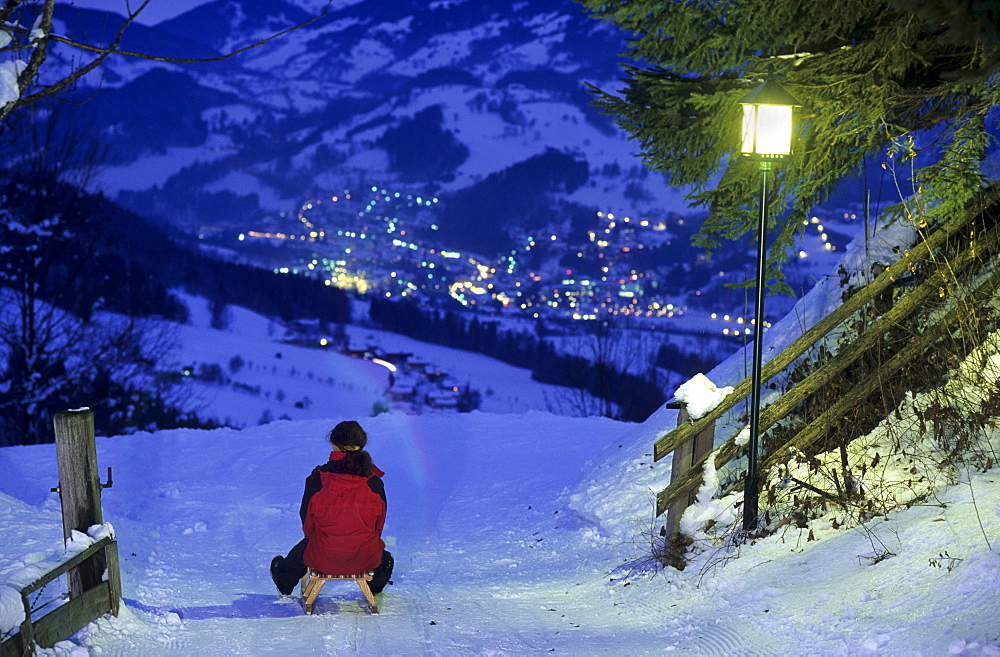 Sledging on illuminated toboggan-run at night, Alpendorf, St. Johann im Pongau, Salzburg, Austria