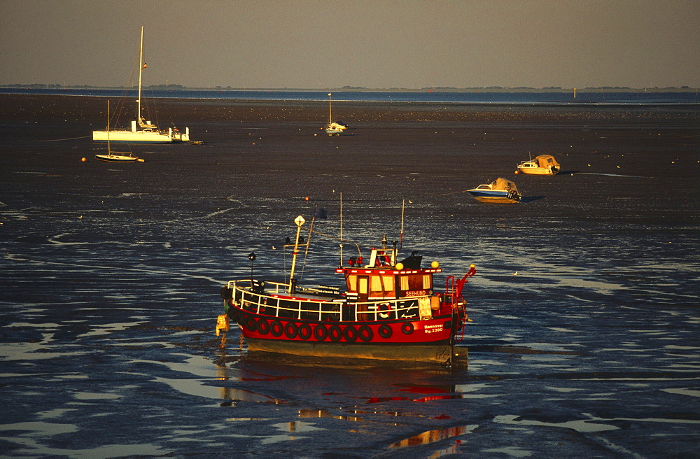 Boats on sandbanks at low tide, East Frisia, Germany