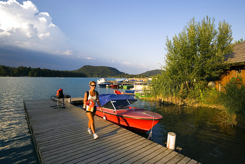 Woman walking over landing stage, Lake Faak, Carinthia, Austria