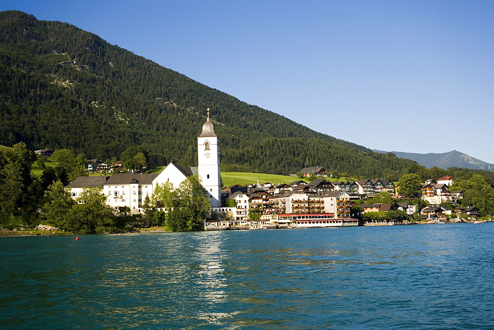 View over lake Wolfgangsee to parish and pilgrimage church and Hotel Im Weissen Roessel am Wolfgangsee, St. Wolfgang, Upper Austria, Salzkammergut, Austria