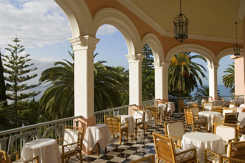 Chairs and tables on the sunlit terrace of Reids Hotel, Funchal, Madeira, Portugal