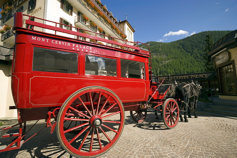 Red carriage of the Mont Cervin Palace parking in front of the Hotel, Zermatt village, Zermatt, Valais, Switzerland