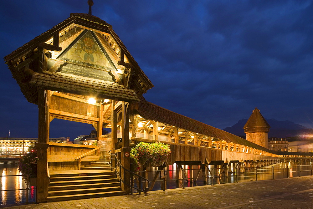 Entry of the Kapellbruecke (chapel bridge, oldest covered bridge of Europe) and Wasserturm in the evening, Jesuit Curch, first large sacral baroque building in Switzerland, in background, Lucerne, Canton Lucerne, Switzerland