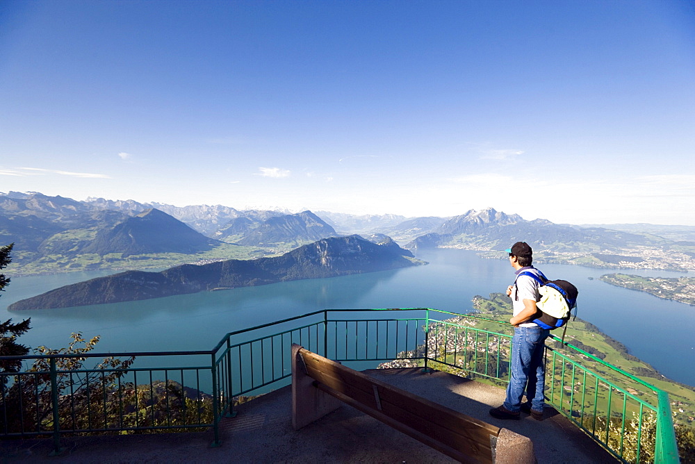 Man standing on vantage point Kaenzli, mount Rigi (1797 m, Queen of the Mountains) and looking over Lake Lucerne with Weggis, mount Buergenstock and mount Pilatus (2132 M), Rigi Kaltbad, Canton of Schwyz, Switzerland