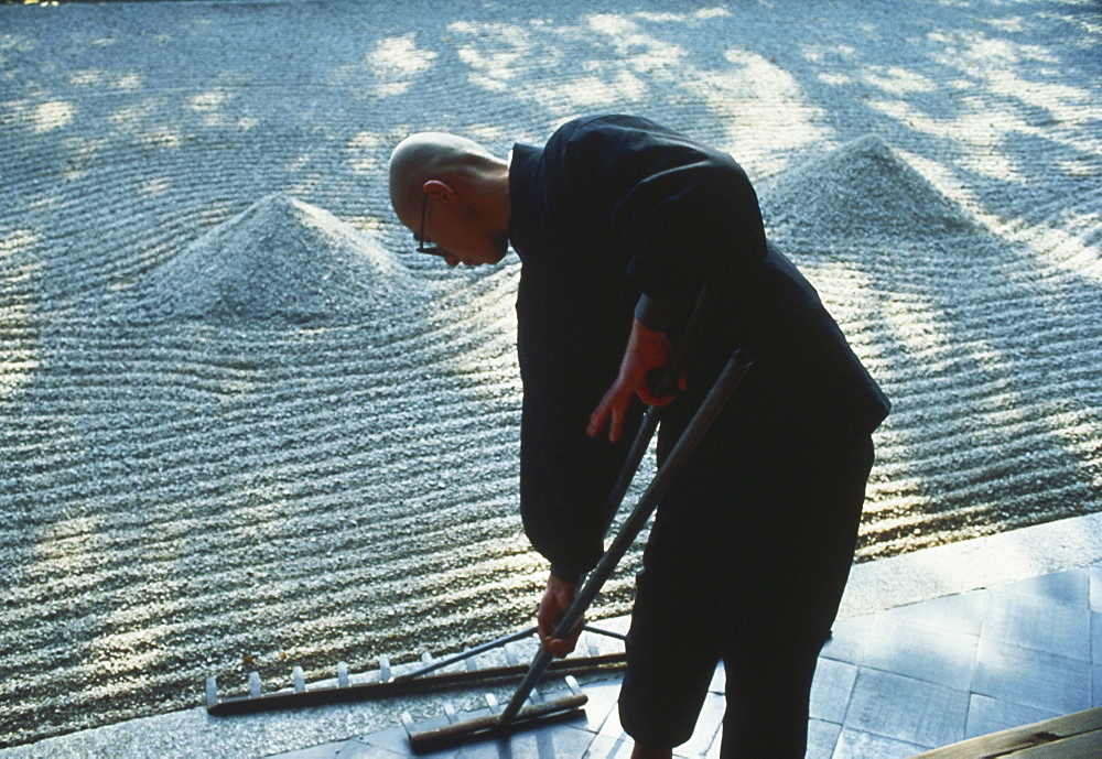 A monk working in the Zen garden, Japan