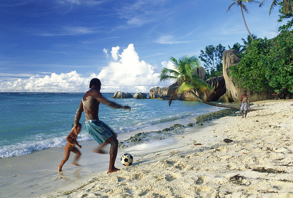 Seychellois playing football on the beach, Anse Source d'Argent, La Digue, Seychelles