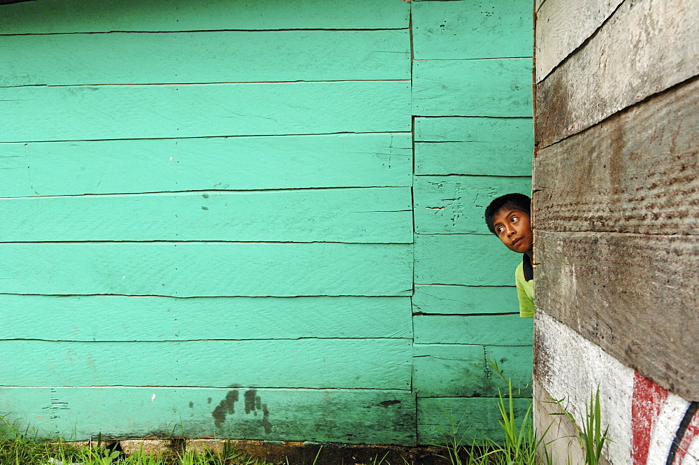 Boy hiding behind wooden wall, Aqua Azul, Chiapas, Mexico