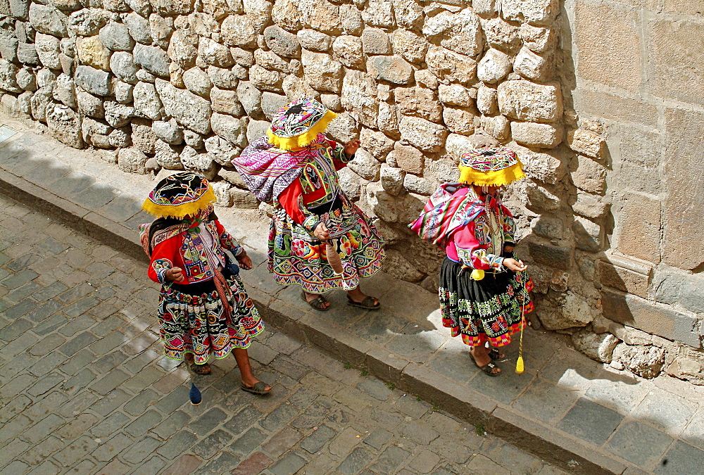 Inca women walking down a cobbled strret in Cusco, Peru, South America