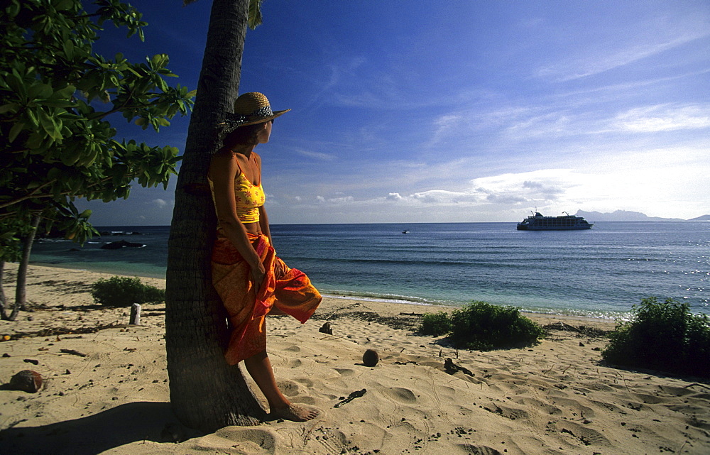 Woman on a sandy beach looking out to sea, Navadra Island, Mamanuca group, Fiji, South Sea