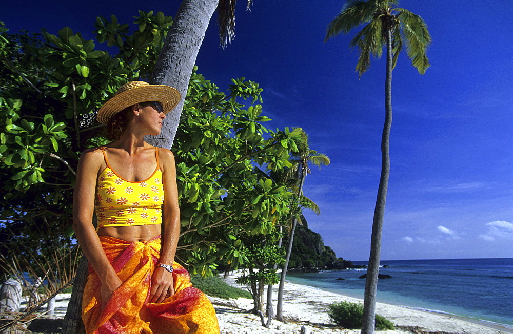 Woman on a sandy beach looking out to sea, Navadra Island, Mamanuca group, Fiji, South Sea