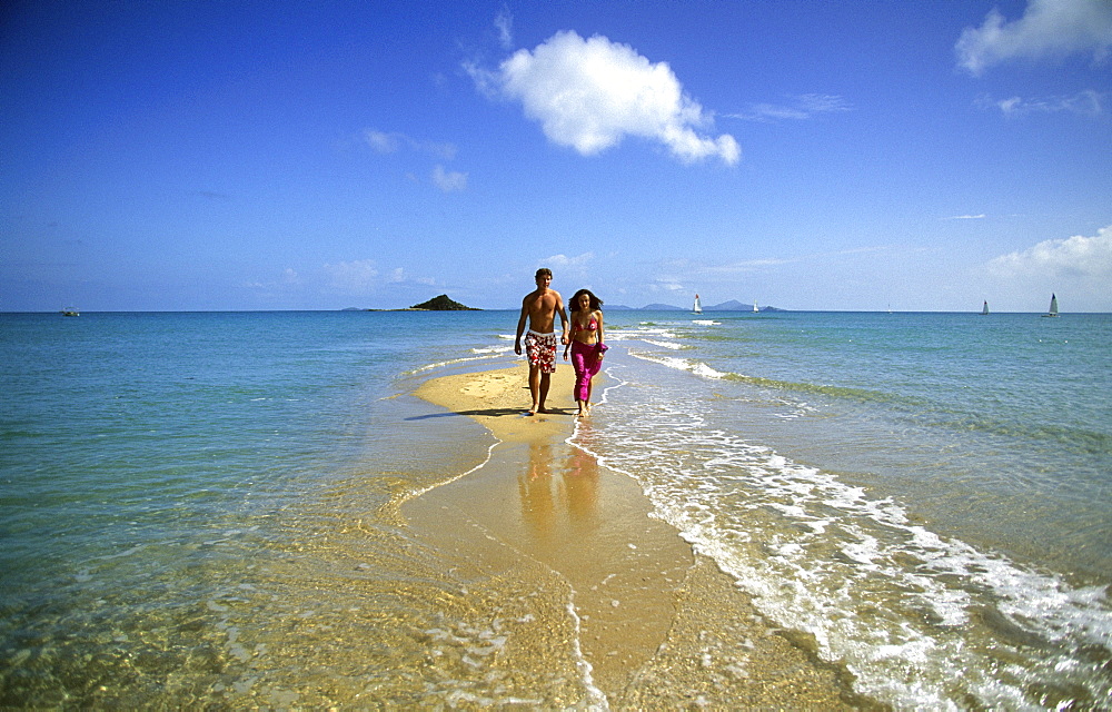 A couple walking along the beach, Sandy Point on Brampton Island, Whitsunday Islands, Great Barrier Reef, Australia