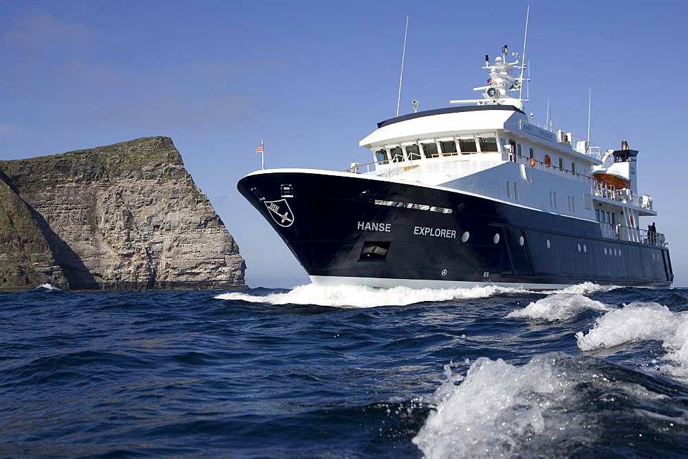 The yacht, ship, Hanse Explorer and the cliffs of the island Noss, Shetland Islands, Scotland, Great Britain