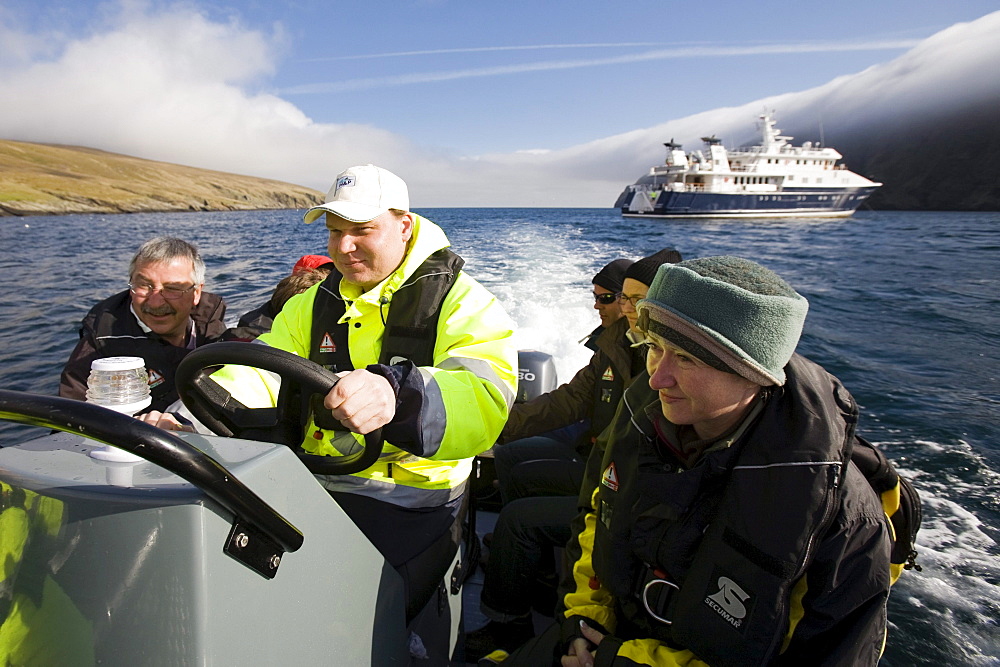 Tourists and seaman in an inflatable rubber boat, Hermaness, island of Unst, Shetland islands, Scotland, UK, Tourists