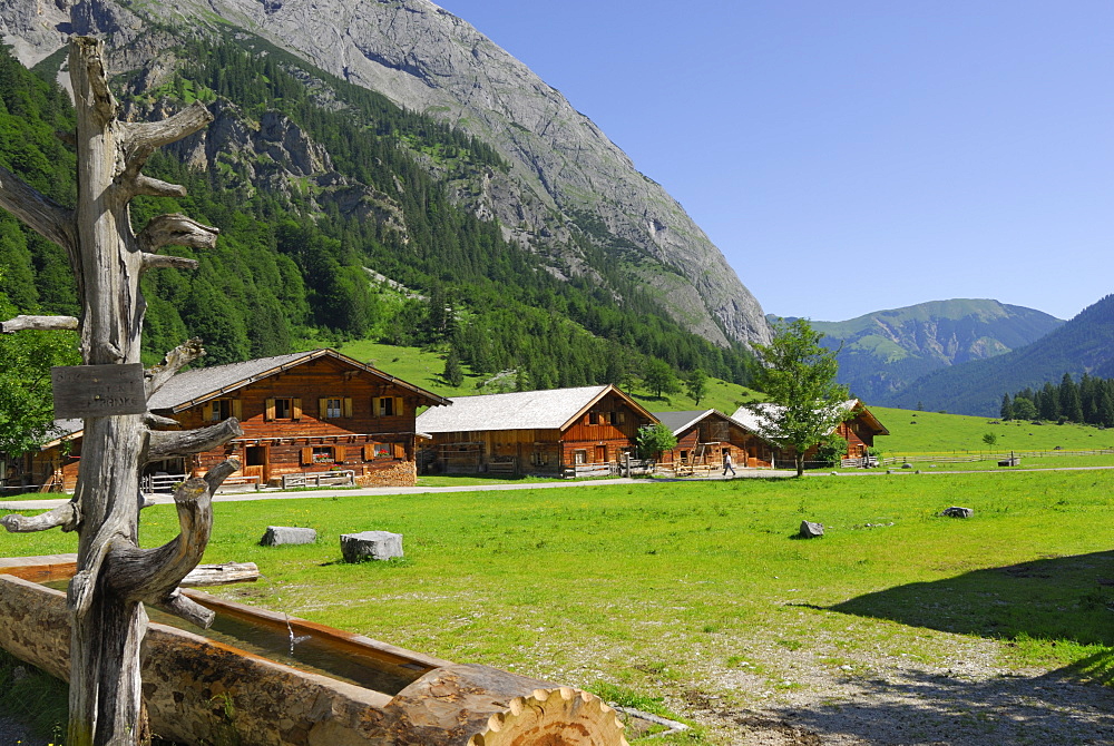 fountain with alpine huts of Enger Alm, Eng, Karwendel range, Tyrol, Austria