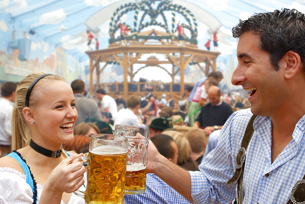 Young couple drinking beer during Oktoberfest, Munich, Bavaria, Germany