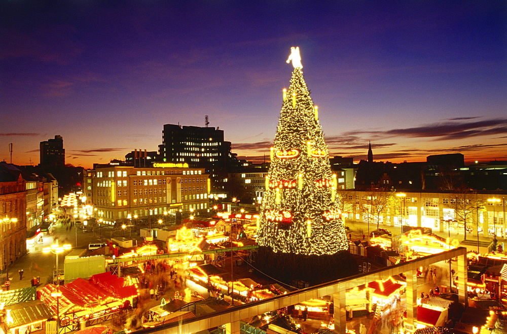 View over Christmas market with giant Christmas tree in the evening, Dortmund, North Rhine-Westphalia, Germany