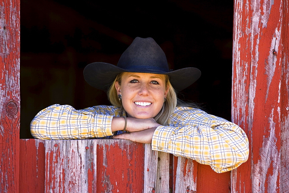 Cowgirl looking out of barn-window, wildwest, Oregon, USA