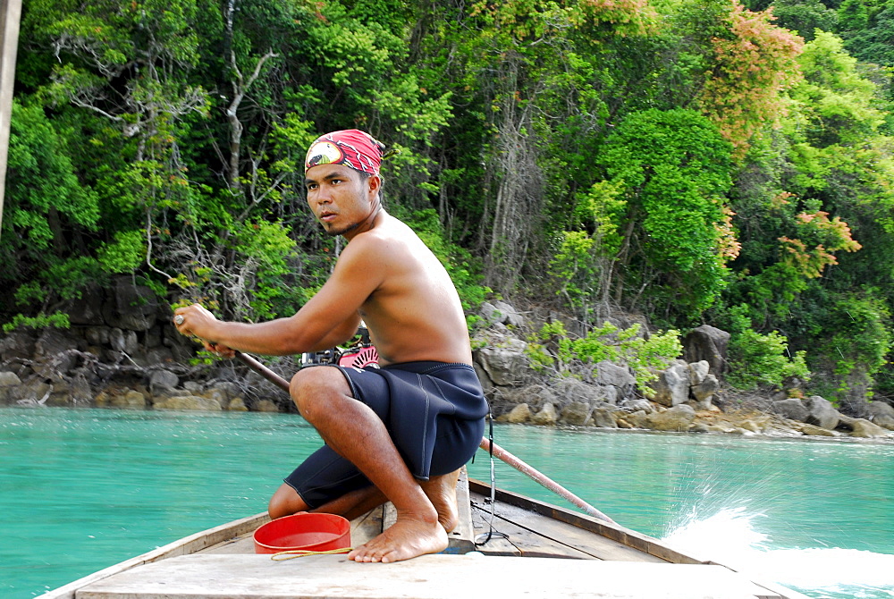 Local man steering a longtail boat, Surin Islands Marine National Park, Ko Surin, Phang Nga, Thailand