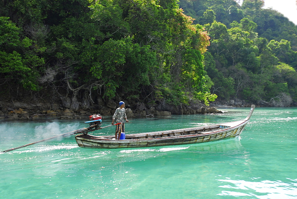 Longtail boat in front of jungle clad island, Surin Islands Marine National Park, Ko Surin, Phang Nga, Thailand