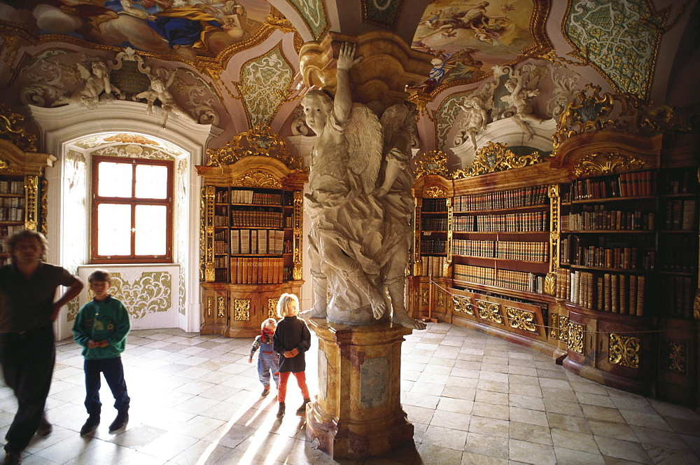 Children gazing at the sculptures on a pillar in the baroque library of the Benedictine abbey, Metten, Lower Bavaria, Germany