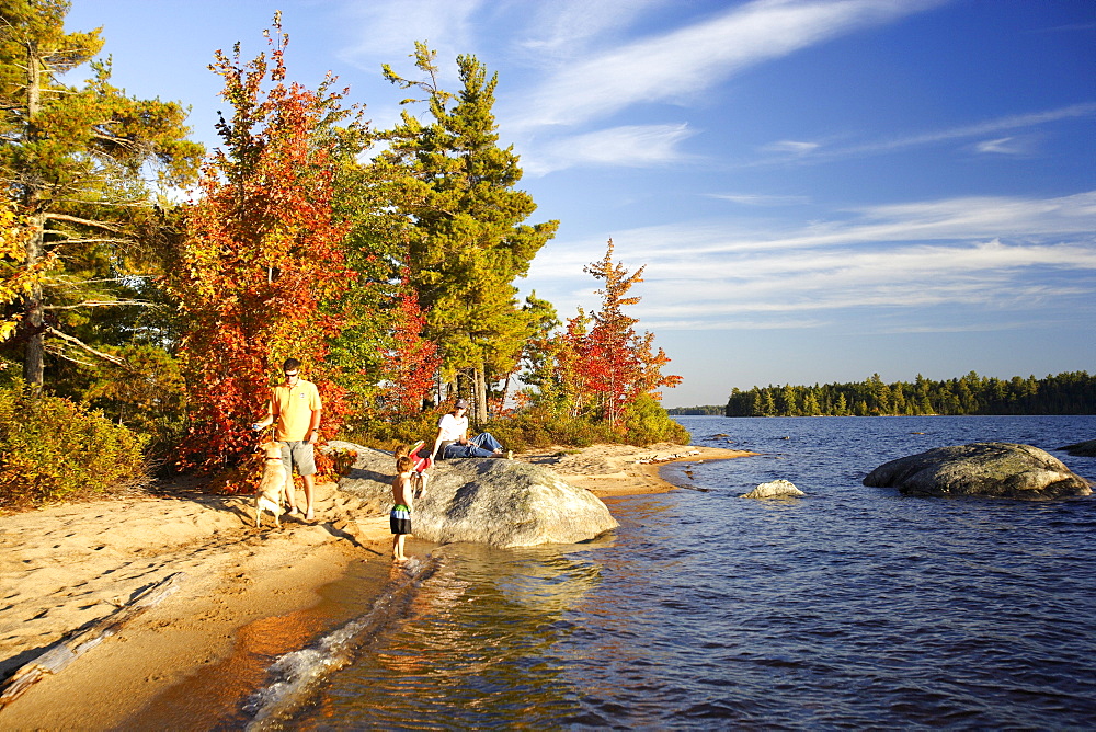 Family on a beach on Lake Millinocket in autumn, Maine, USA