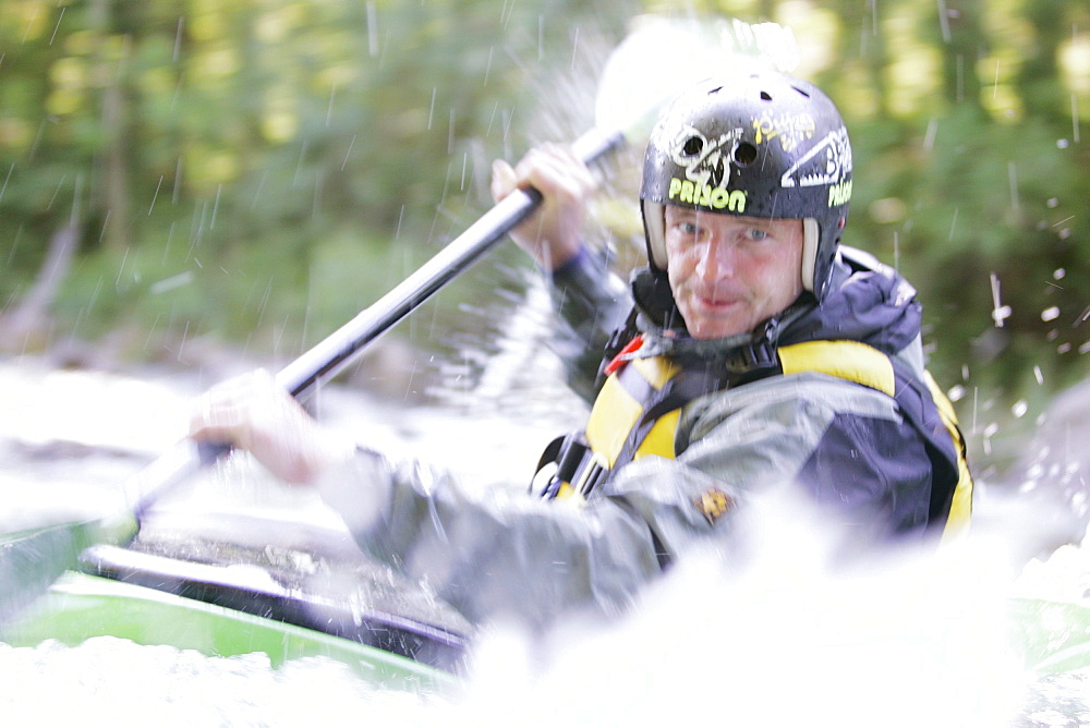 Man, Kayak guide, in a kayak, kayak weekend for beginners on the Mangfall river, Upper Bavaria, Germany