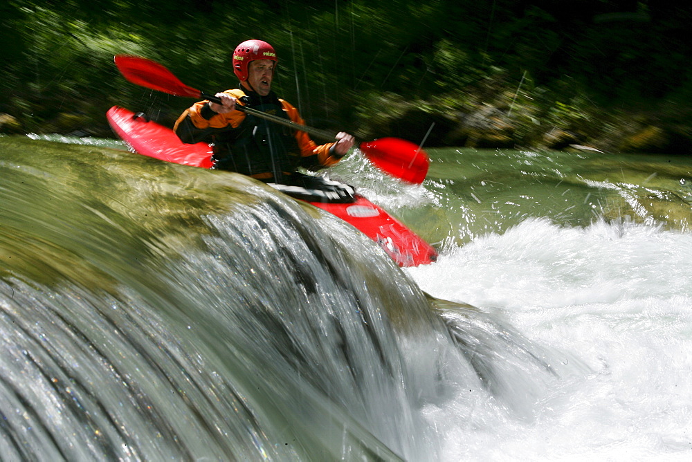 Man paddling through whitewater, kayak weekend for beginners on the Mangfall river, Upper Bavaria, Germany