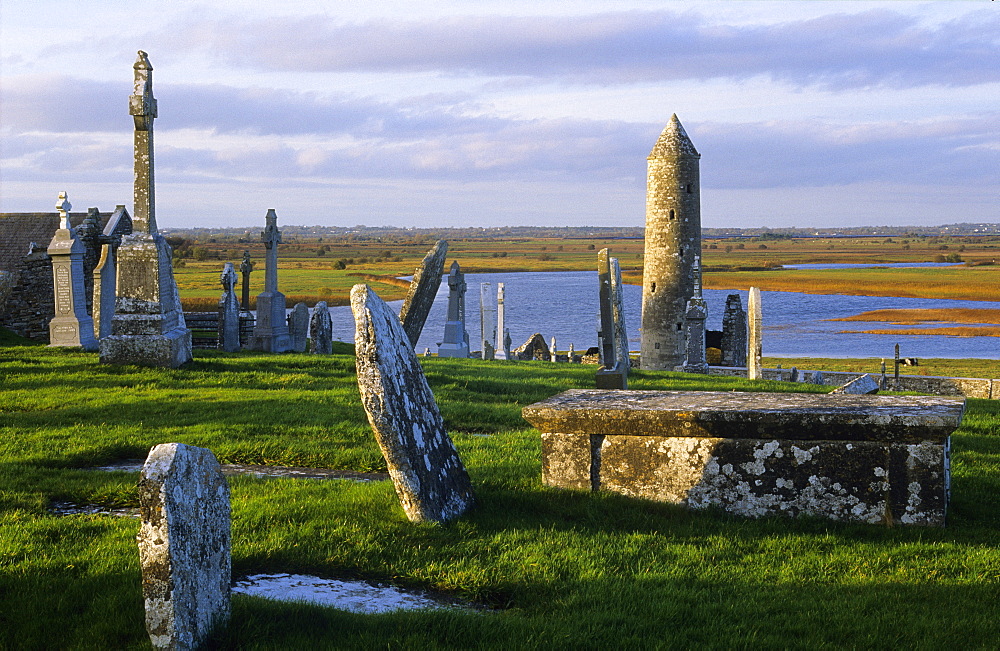 Ruins of the monastery of Clonmacnoise with gravestones and tower, County Offaly, Ireland, Europe