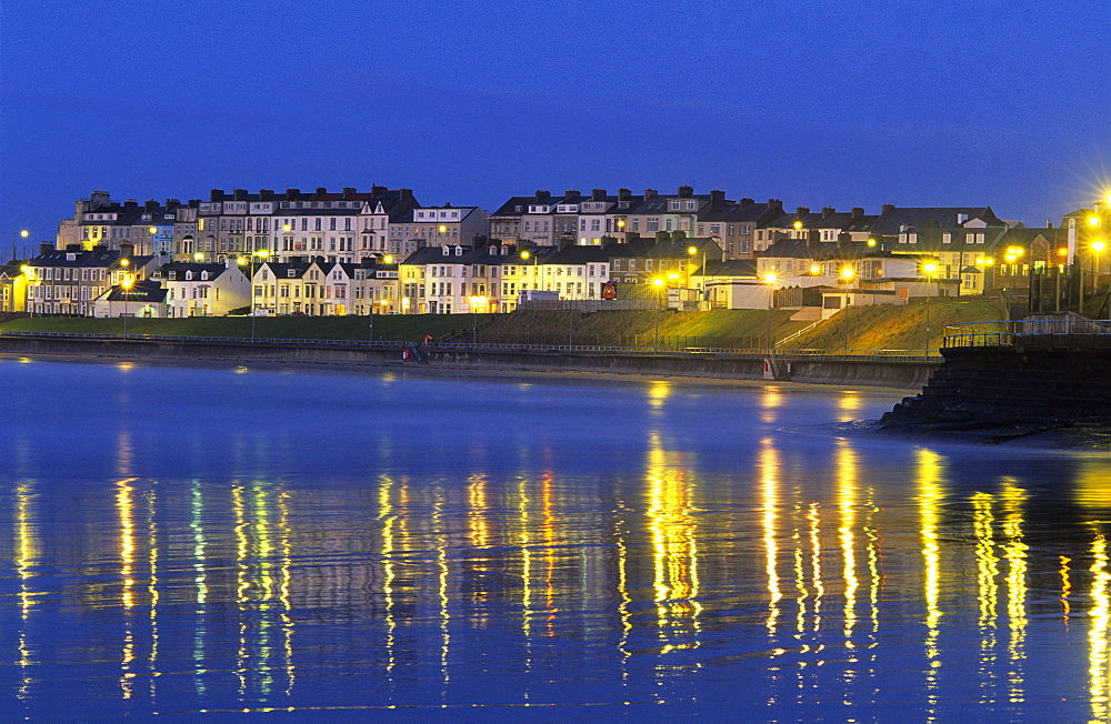 View at illuminated houses on shore in the evening, Portrush, County Antrim, Ireland, Europe