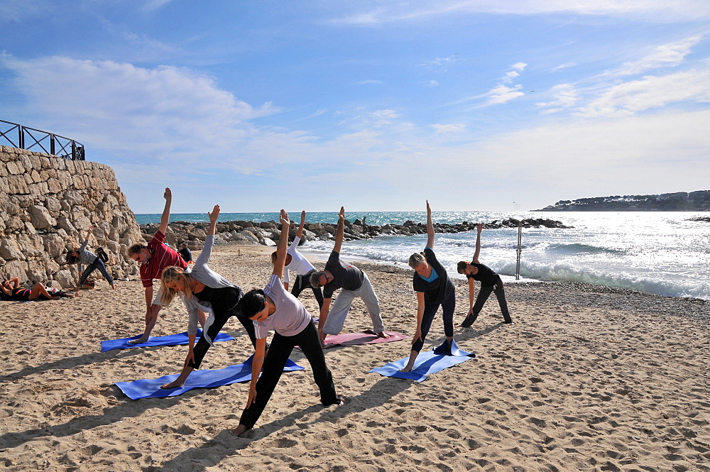 People doing yoga on the beach Plage de la Gravette, Antibes, Cote d'Azur, South France, Europe