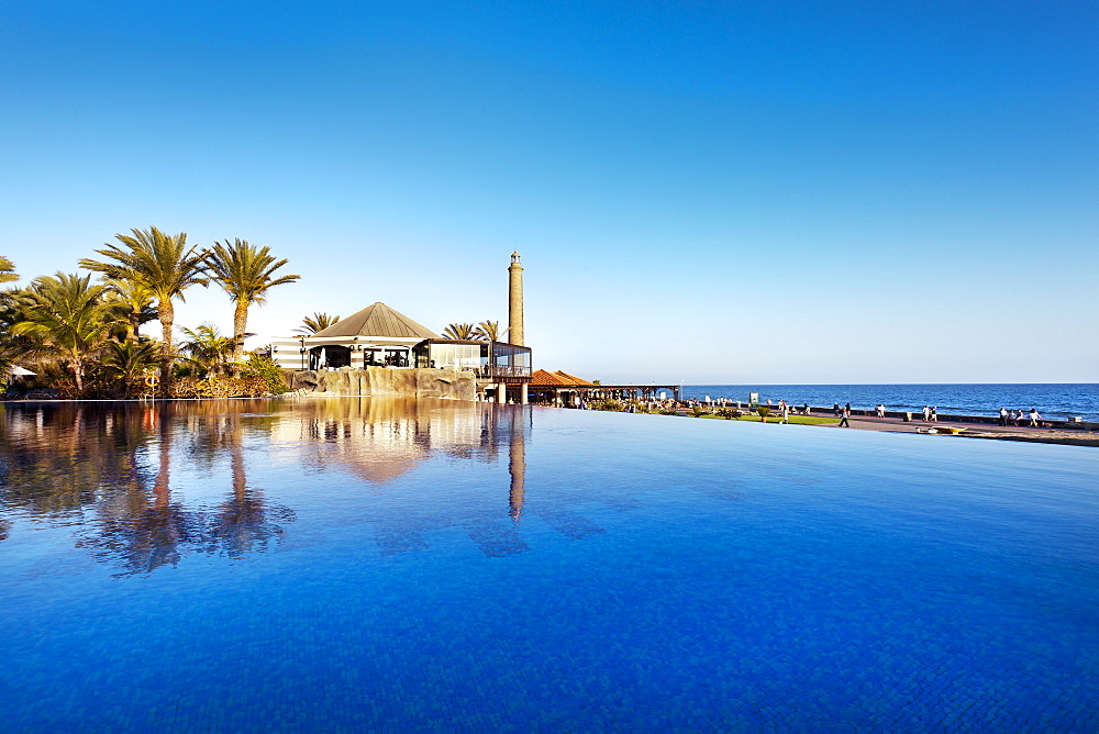 Pool of the Grand Hotel Costa and lighthouse under blue sky, Meloneras, Maspalomas, Gran Canaria, Canary Islands, Spain, Europe