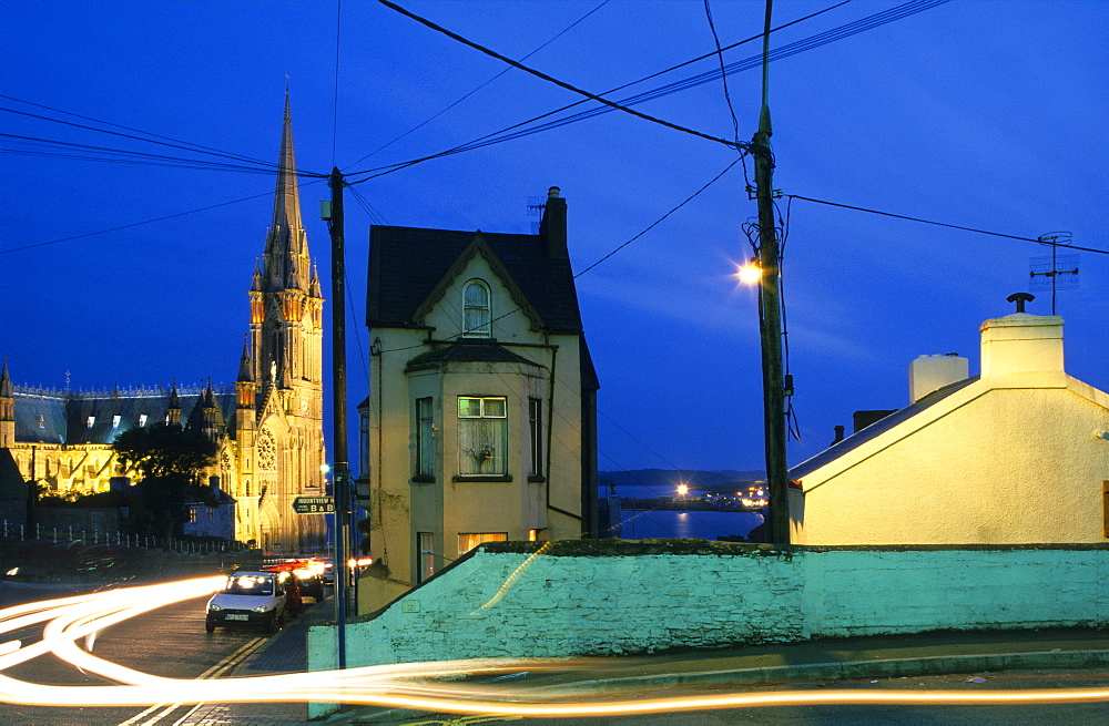 Calm street setting and the illuminated St. Colman's cathedral in the evening, Cobh, County Cork, Ireland, Europe