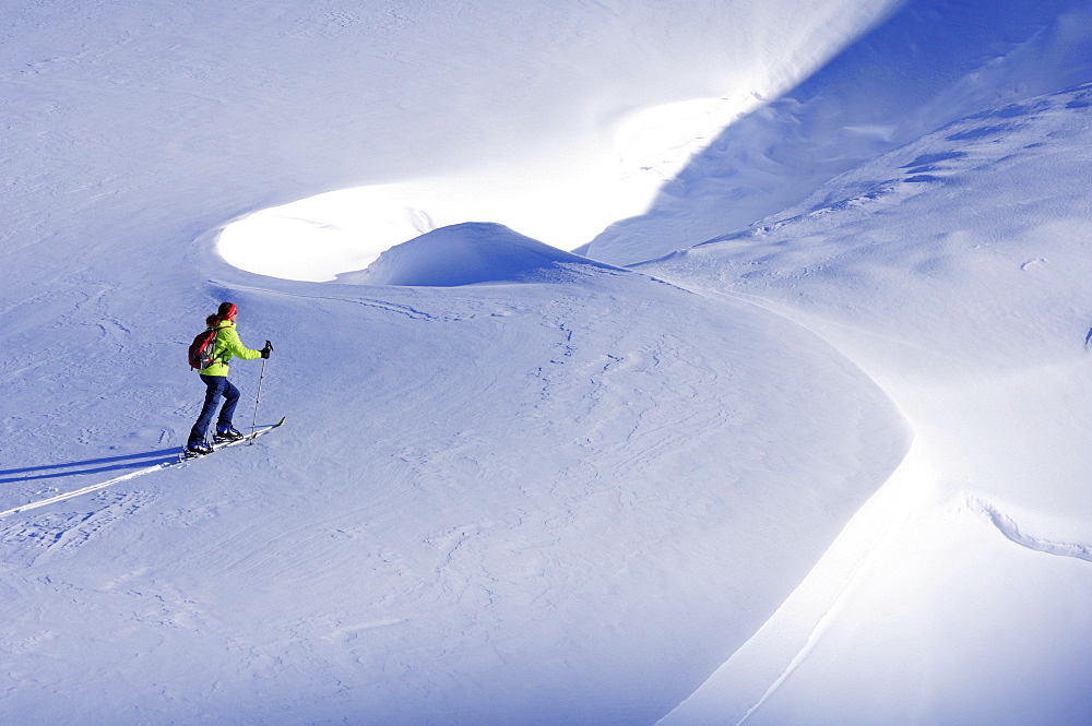 Woman backcountry skiing crossing a snowface, Nadernachjoch Skitour, Neue Bamberger hut, Kitzbuehel Alps, Tyrol, Austria