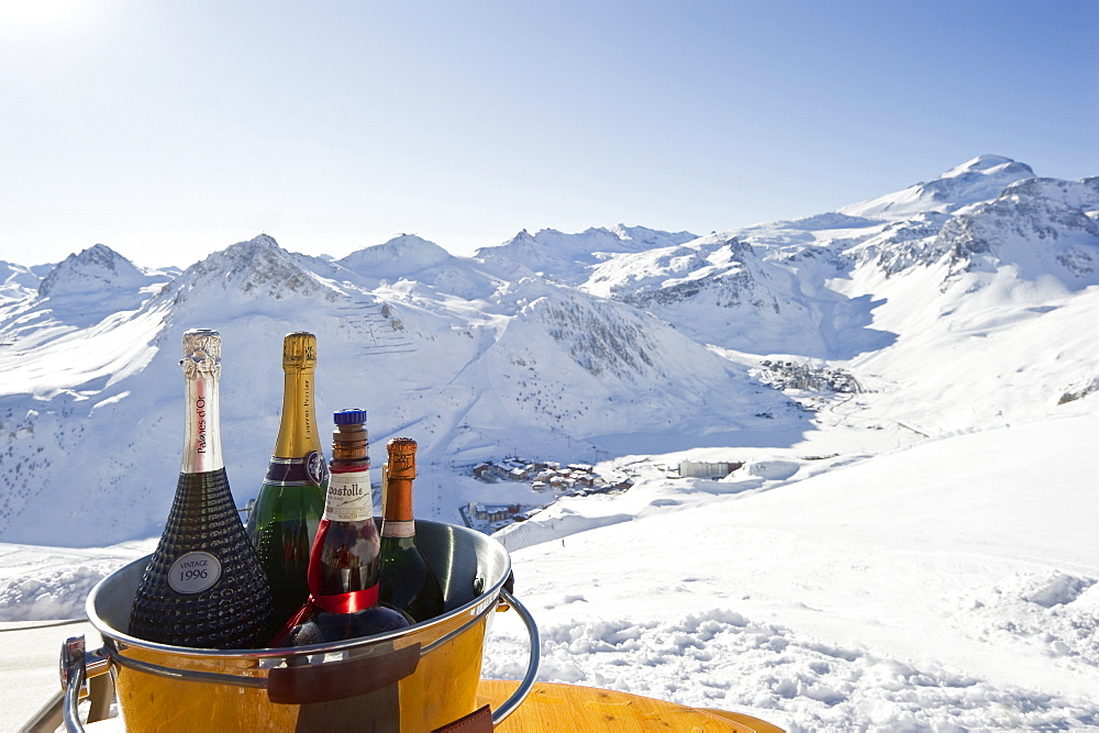 Bottles of champagne in a cooler, Snow-capped mountains in the background, Tignes, Val d Isere, Savoie department, Rhone-Alpes, France