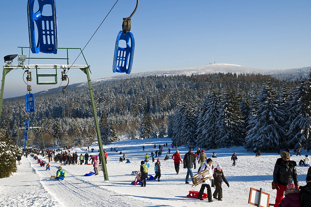 Children sledging, Sledge lift, sledge hill Torfhaus, Brocken in background, Altenau, Harz, Lower Saxony, Germany