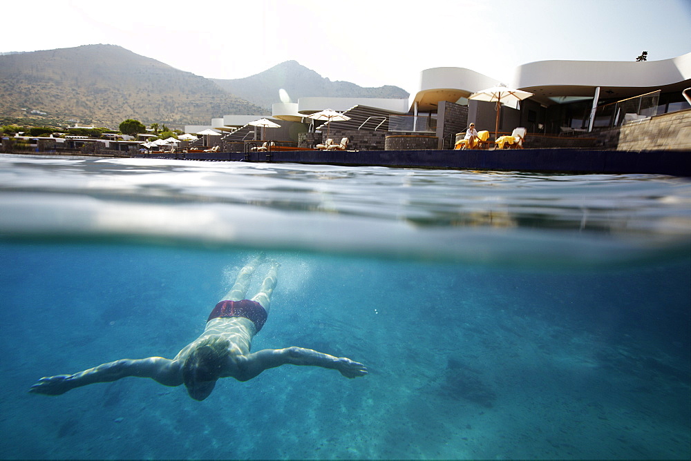 Diver underwater in front of Yachting Club Villas, Elounda Beach Resort, Elounda, Crete, Greece